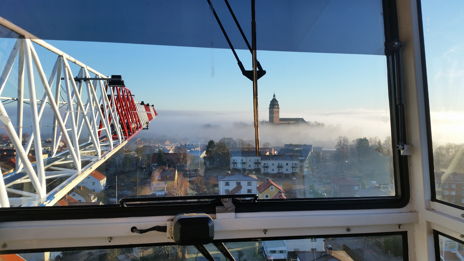 Vy från lyftkran över Strängnäs med domkyrkan i morgondiset