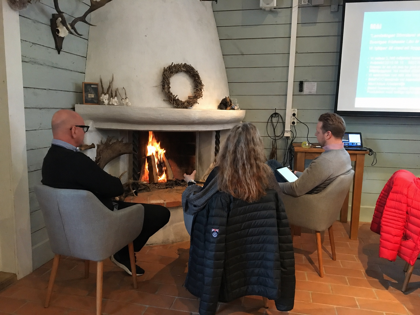Workshop framför öppen brasa med deltagare och projektorbild
